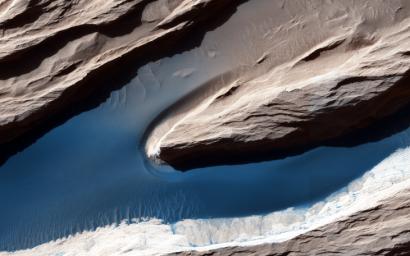 The wind has carved features, called yardangs, one of many in this scene, and deposited sand on the floor of shallow channels between them as seen by NASA's Mars Reconnaissance Orbiter spacecraft.