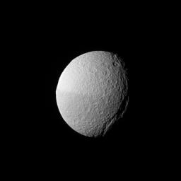 NASA's Cassini spacecraft shows the low angle of the sun over Tethys' massive canyon, Ithaca Chasma (near the terminator, at right), highlights the contours of this enormous rift.