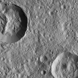 This image from NASA's Dawn spacecraft features a relatively fresh crater on Ceres with prominent spurs of compacted material and gullies along its rim. Boulders of a variety of sizes litter the crater's floor and the area around its rim.