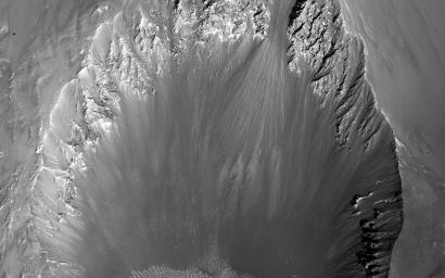 This image from NASA's Mars Reconnaissance Orbiter spacecraft shows a roughly 3-kilometer impact crater, formed on the sloping walls of Tithonium Chasma, part of the large Valles Marineris canyon system.