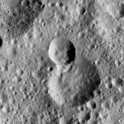 This picture from NASA's Dawn spacecraft shows terrain on Ceres in which the rim of a more recent impact crater, at center, has partially collapsed into its adjacent neighbor, just below. Boulders are visible in and around the younger, smaller crater.