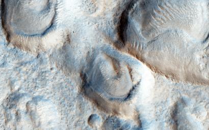 This image from NASA's Mars Reconnaissance Orbiter spacecraft covers mesas, or high-standing plateaus, to the north and pits, or low-standing, depressions to the south. What formed these mesas and pits is a question not so easy to answer.