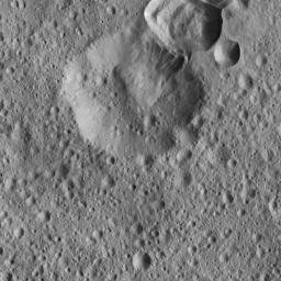 This view from NASA's Dawn spacecraft shows impact craters near Ceres' equator where material from the rim of one crater has apparently collapsed into its neighbor. A variety of large boulders are visible within the younger crater at top.