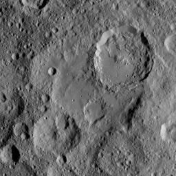 Ikapati Crater on Ceres is seen at top right in this image from NASA's Dawn spacecraft taken on Oct. 24, 2016. Ikapati has a complex of central peaks and roughly parallel fractures on its floor.