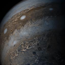 This enhanced-color image of Jupiter's bands of light and dark clouds was created with data from the JunoCam imager on NASA's Juno spacecraft. Three of the white oval storms known as the 'String of Pearls' are visible near the top of the image.