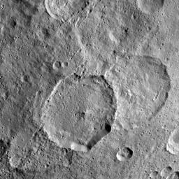 Inamahari Crater on Ceres, the large well-defined crater at the center of this image from NASA's Dawn spacecraft, is one of the sites where scientists have discovered evidence for organic material.