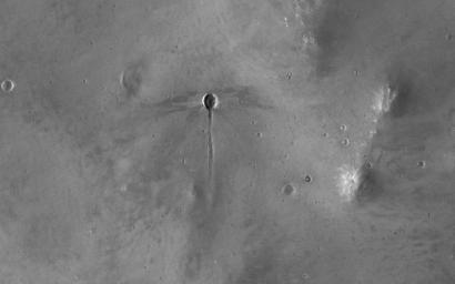 The broader scene for this image from NASA's Mars Reconnaissance Orbiter is the fluidized ejecta from Bakhuysen Crater to the southwest. A 'dragonfly' impact crater i seen with a gouged-out trench extending to the south.