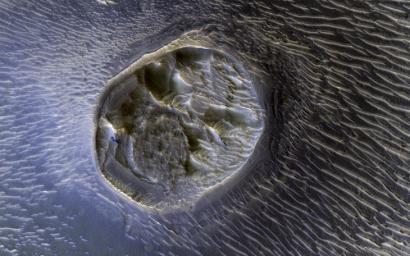 This small mesa is one of several surrounded by sand dunes in Noctis Labyrinthyus, an extensively fractured region on the western end of Valles Marineris, as seen by NASA's Mars Reconnaissance Orbiter.