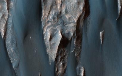 Dark, windblown sand covers intricate sedimentary rock layers in this image captured by NASA's Mars Reconnaissance Orbiter (MRO) from Ganges Chasma, a canyon in the Valles Marineris system.