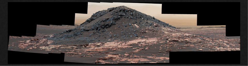 This dark mound, called 'Ireson Hill,' rises about 16 feet (5 meters) above redder layered outcrop material of the Murray formation on lower Mount Sharp, Mars, near a location where NASA's Curiosity rover examined a linear sand dune in February 2017.