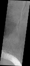 This image from NASA's 2001 Mars Odyssey spacecraft shows part of the two summit calderas of Pavonis Mons. The surface in the majority of the image is the floor of the larger caldera.