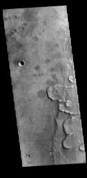 This image from NASA's 2001 Mars Odyssey spacecraft shows a portion of the ejecta deposit of Yuty Crater. The raised edge of the ejecta is termed a rampart, and indicates that a volatile like water may have been present.