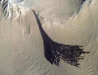 This image from NASA's Mars Reconnaissance Orbiter (MRO) shows streaks forming on slopes when dust cascades downhill. The dark streak is an area of less dust compared to the brighter and reddish surroundings.