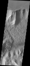 This image of Tithonium Chasma from NASA's 2001 Mars Odyssey spacecraft shows the canyon wall at the top of the frame and the cliff face of the opposite side of the canyon at the bottom of the image.