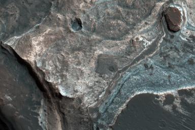 This image from NASA's Mars Reconnaissance Orbiter (MRO) shows the western wall of a small pit that is located along the floor of a larger trough in Coprates Catena. Dark layers line the bottom; light-toned layers are near the top.