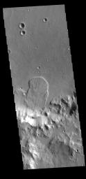 This image captured by NASA's 2001 Mars Odyssey spacecraft is located in an unnamed crater within Tyrrhena Terra. The 'mitten' shaped feature extends from the crater rim (bottom of frame) onto the crater floor.
