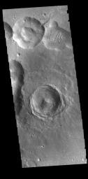This image captured by NASA's 2001 Mars Odyssey spacecraft shows several craters. The interior of the central one has retained much of the original topography, including the central peak.