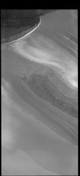 This image from NASA's 2001 Mars Odyssey spacecraft shows part of the margin of the north polar cap and the surrounding plains. The layering of the ice is easily visible due to the dust that is deposited on the top of the ice every year.