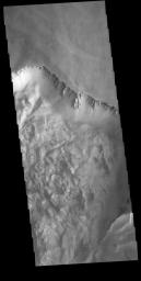This image from NASA's Mars Odyssey shows part of the northern cliff face of Melas Chasma and the large landslide deposits at the base of the cliff face.