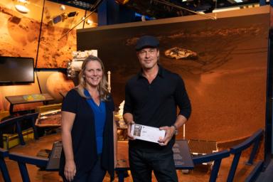 The actor Brad Pitt (right) shows off his 'boarding pass' for Mars with Jennifer Trosper (left), the Mars 2020 project systems engineer, at JPL on Sept. 6, 2019.