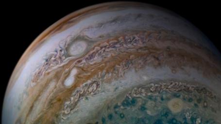 This view of Jupiter's atmosphere from NASA's Juno spacecraft includes something remarkable, two storms caught in the act of merging.