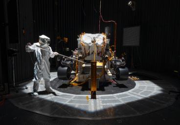 An engineer working on NASA's Mars 2020 mission uses a solar intensity probe to measure and compare the amount of artificial sunlight that reaches different portions of the rover.