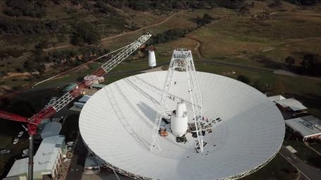 In a delicate operation, a 400-ton crane lifts the new X-band cone into the 70-meter (230-feet) Deep Space Station 43 dish located in Canberra, Australia.