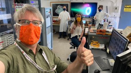 Thumbs-up for a successful test. Psyche engineers test an electric Hall thruster identical to those that will propel NASA's Psyche spacecraft on its journey to the asteroid Psyche.