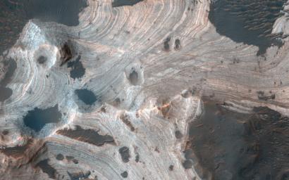 This image acquired on April 13, 2020 by NASA's Mars Reconnaissance Orbiter, reveals exquisite layering emerging from the sand in southern Holden Crater.