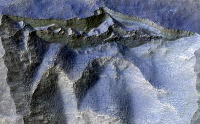 This image acquired on August 15, 2020 by NASA's Mars Reconnaissance Orbiter, shows a brownish, dusty cliff wall, where the faint light-blue-colored ice shows through.