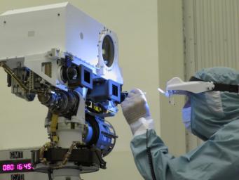 A JPL optical technician performs a final inspection and swab cleaning of the front optics of the Mars 2020 mission's Perseverance rover Mastcam-Z cameras at the Kennedy Space Center in Florida in March 2020.