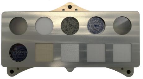 The calibration target for SHERLOC, one of the instruments aboard NASA's Perseverance Mars rover, features a slice of Martian meteorite, plus spacesuit materials, including helmet-visor material that doubles as a geocache target.