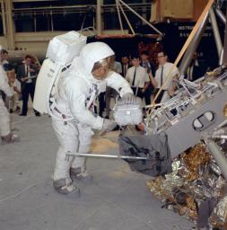Apollo 11 commander Neil Armstrong works with an Apollo Lunar Sample Return Container during a lunar surface simulation training exercise in Building 9, Manned Spacecraft Center in Houston, Texas.