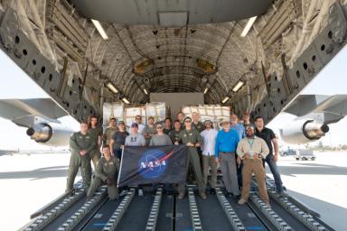 Some of the people who helped to load the hardware for the Surface Water and Ocean Topography (SWOT) satellite's research instruments onto a C-17 airplane pose for a picture. The payload left March Air Reserve Base on June 27 and is headed to France.