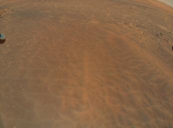 NASA's Ingenuity Mars Helicopter flew over this dune field in a region of Jezero Crater nicknamed Séítah during its ninth flight, on July 5, 2021. A portion of the helicopter's landing gear can be seen at top left.