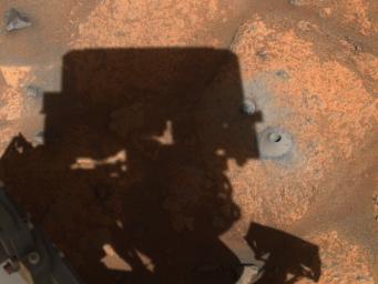 The drill hole from Perseverance's first sample-collection attempt can be seen, along with the shadow of the rover, in this image taken by one of the rover's navigation cameras.