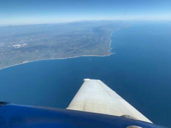 A research plane collecting spectral imaging data of vegetation on land and in the ocean as part of the SHIFT campaign flies just off the Central Coast of California in February.