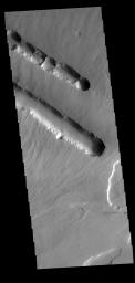 This image from NASA's Mars Odyssey shows two depression crossing called Pavonis Fossae that are located on the northern lower flank of Pavonis Mons.