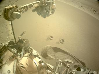 Two holes are left in the Martian surface after NASA's Perseverance rover used a specialized drill bit to collect the mission's first samples of regolith on Dec. 2 and 6, 2022.