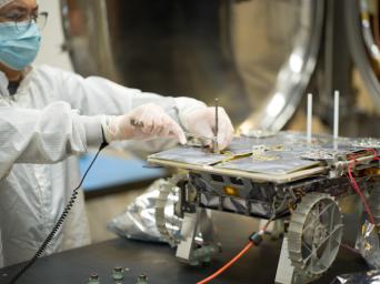 An engineer prepares a small rover – part of NASA's CADRE technology demonstration – for testing in a thermal vacuum chamber at the agency's Jet Propulsion Laboratory in Southern California in October 2023.
