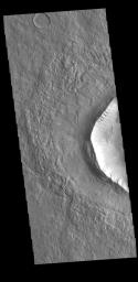 This image from NASA's Mars Odyssey shows part of an unnamed crater in Utopia Planitia. The ejecta surrounding the crater rim shows both layering and radial grooves. These features formed during the impact event.