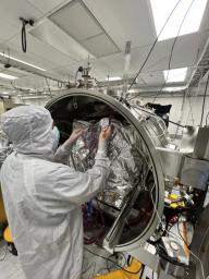 An engineer prepares the imaging spectrometer instrument for testing in a thermal vacuum chamber at JPL. The instrument will be part of an effort led by the nonprofit Carbon Mapper organization to collect data on greenhouse gas point-source emissions.