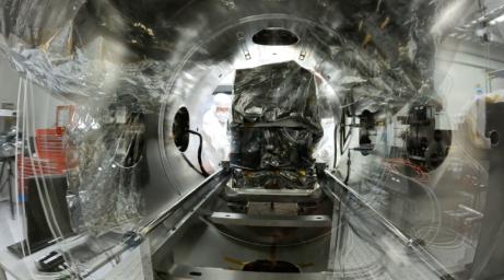 A technician slides the imaging spectrometer into a thermal vacuum test chamber at JPL in July 2023. Engineers use the chamber to subject the spectrometer to the extreme temperatures it will encounter in the vacuum of space.