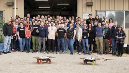 Members of NASA's CADRE technology demonstration team pose with two full-scale development model rovers in the Mars Yard at the agency's Jet Propulsion Laboratory in Southern California in January 2024.