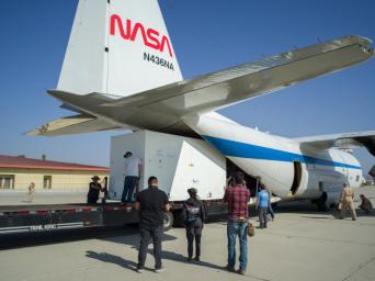 A container holding NISAR's radar antenna reflector is loaded into NASA's C-130 cargo plane at March Air Reserve Base in Riverside County, California, on Oct. 15, 2024.