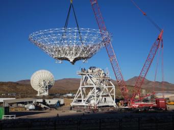 A crane lowers the steel reflector framework for Deep Space Station 23 into position Dec. 18, 2024. Panels will be affixed to the structure create a curved surface to collect radio frequency signals.