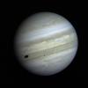 Jupiter's satellite Io poses before the giant planet in this photo returned January 17, 1979. The satellite's shadow can be seen falling on the face of Jupiter at left. Io is traveling from left to right in its orbit around Jupiter.