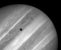 This image from NASA's Hubble Space Telescope shows Jupiter's volcanic moon Io passing above the turbulent clouds of the giant planet, on July 24, 1996. The conspicuous black spot on Jupiter is Io's shadow.