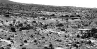 This image taken on the morning of Sol 80 (September 23, 1997) shows NASA's Sojourner rover with its Alpha Proton X-ray Spectrometer (APXS) deployed against the rock 'Chimp.' On the left horizon is the rim of 'Big Crater,' 2.2 km away.