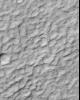 NASA's Mars Global Surveyor shows rounded, rocky ridges separated by lowlands filled with sand or dust in a complex, ridged terrain in North Terra Cimmeria on Mars.